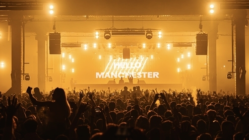 Photo of a yellow-lit stage and crowd at the Depot Mayfield 