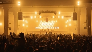 Photo of a yellow-lit stage and crowd at the Depot Mayfield 