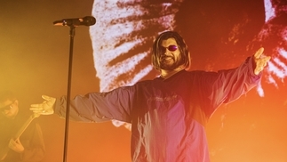 Photo of Jai Paul performing at Coachella wearing a parka coat and sunglasses