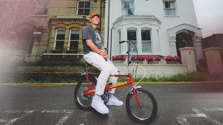 Photo of Melvo Baptiste on a red chopper bike on a street in Watford 