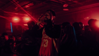 Hamdi performs live in a dark red club space