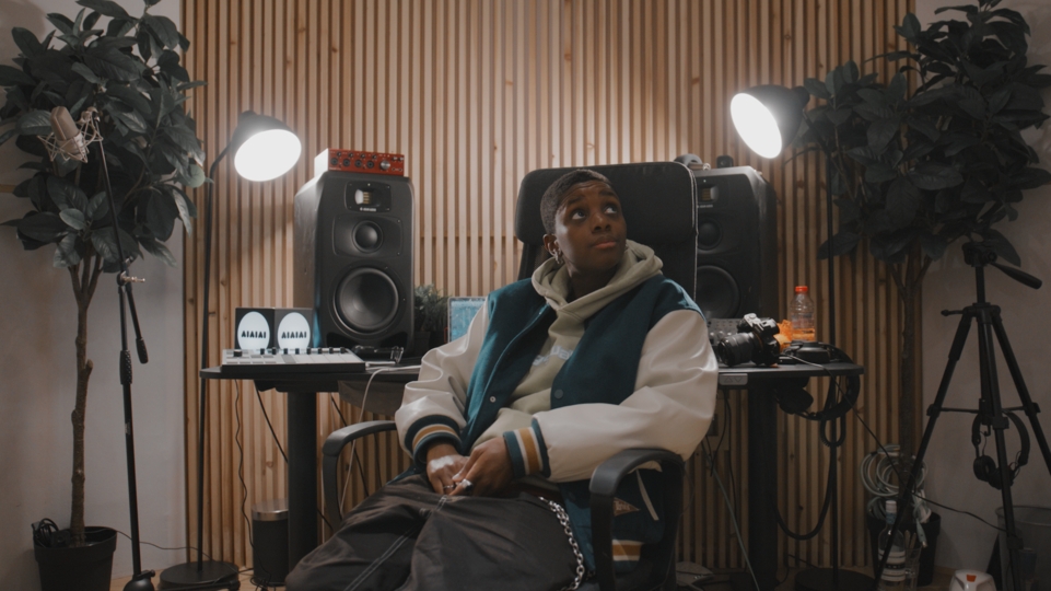 Photo of SHERELLE sitting on a chair in the new community studio launched with AIAIAI.