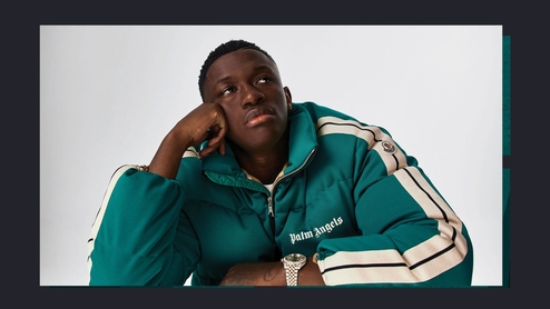 Hardy Caprio sitting at a reflective table in a green and cream 