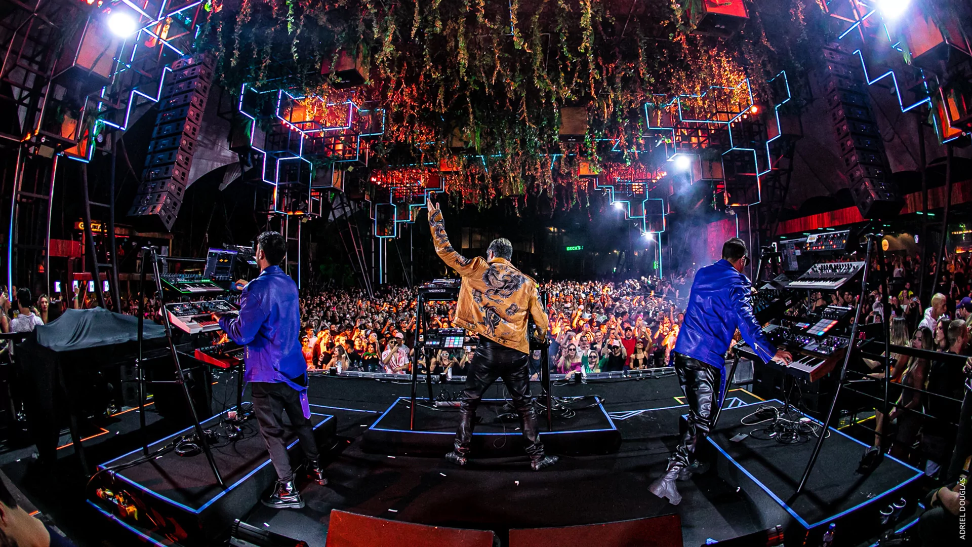 Photo from behind of MEDUZA playing live in front of a large audience with confetti falling from the ceiling