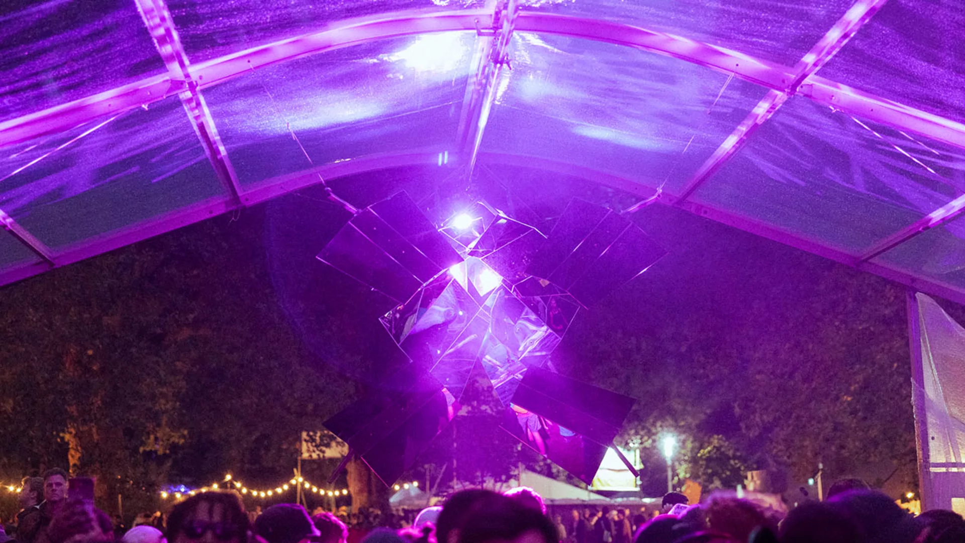 Shot of the glass ceiling at the Lectern Stage at rally festival, where a hanging decoration made of mirrors disperses purple light around